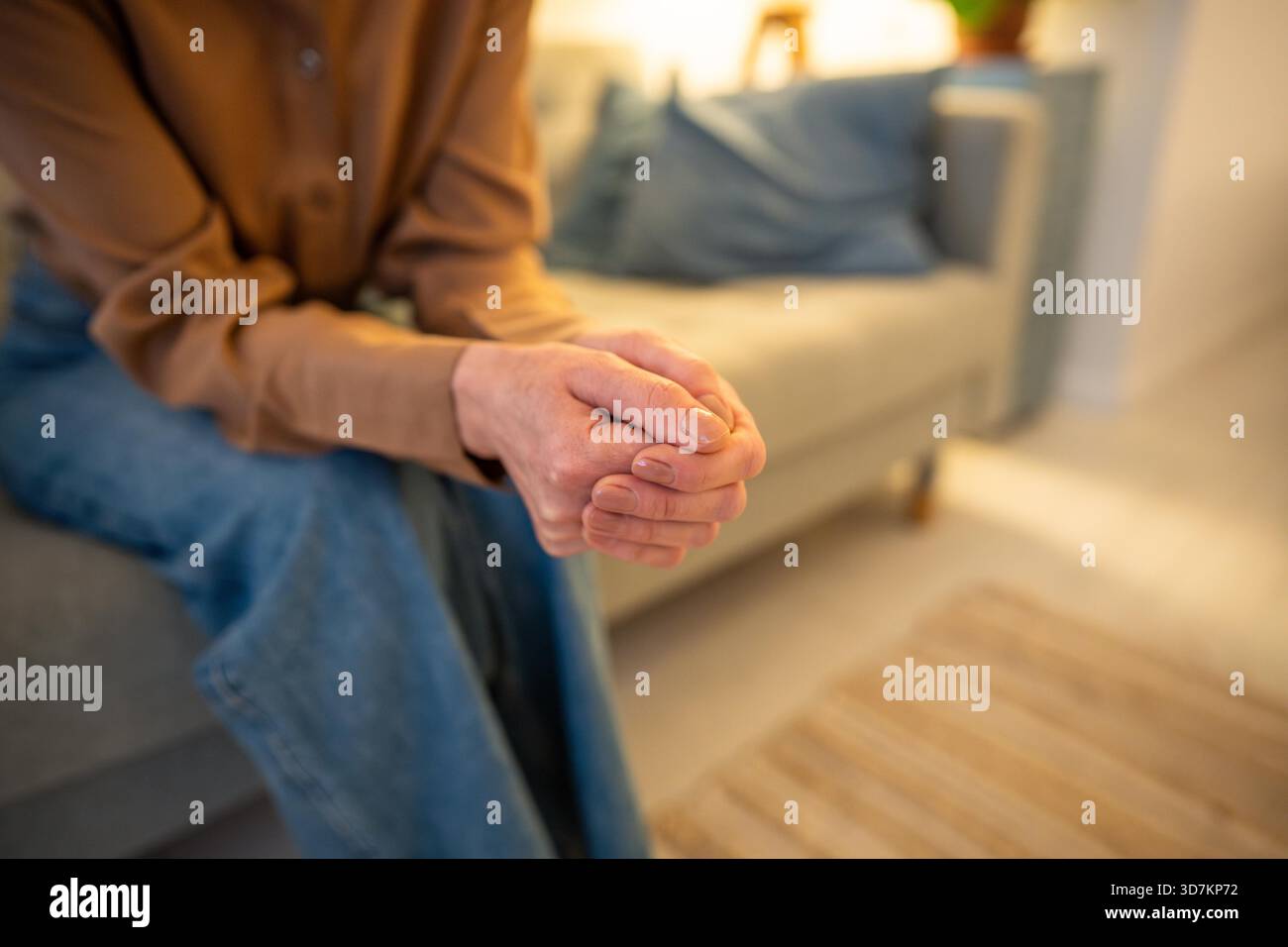 Worried female hands clasped in closed vulnerable posture on mental ...