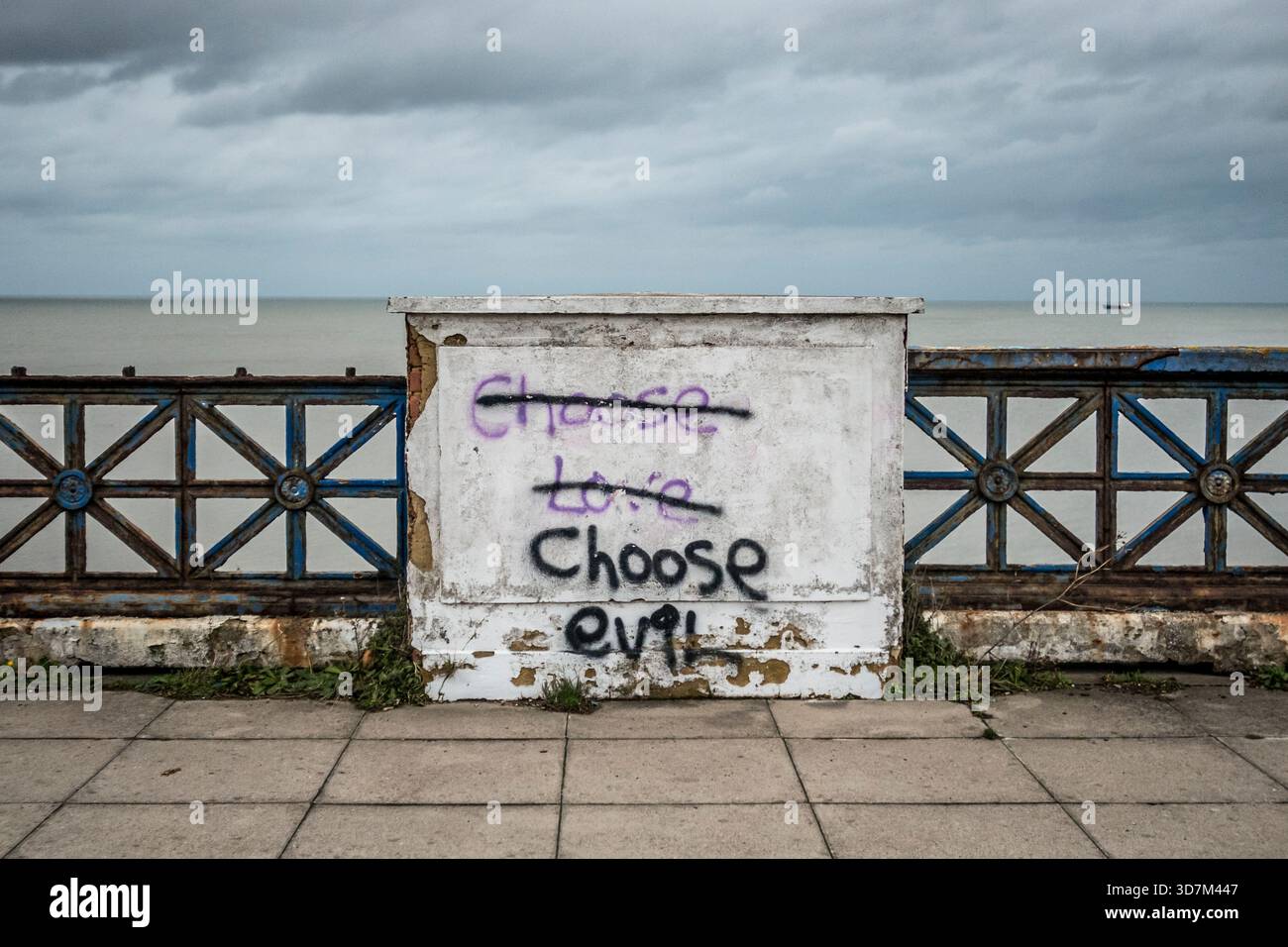 Graffiti on the sea front at Margate - 'Choose Love' erased and replaced with 'Choose Evil' (Kent, UK) Stock Photo
