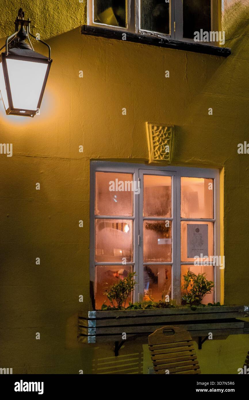 Cozy Nighttime Pub Window with Warm Light and Empty Wooden Table ...
