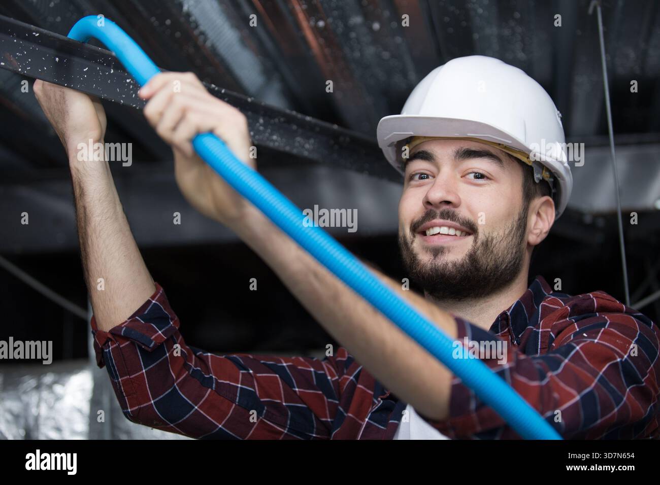 a plumber checking ceiling pipes Stock Photo