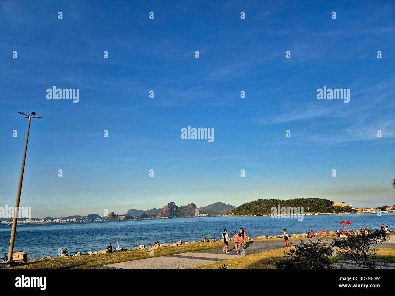 Coastal views and mountain blues under a vast sky. There's nothing quite like watching the waves meet the shore, especially with those beautiful hills - Smartphone Captured Stock Image