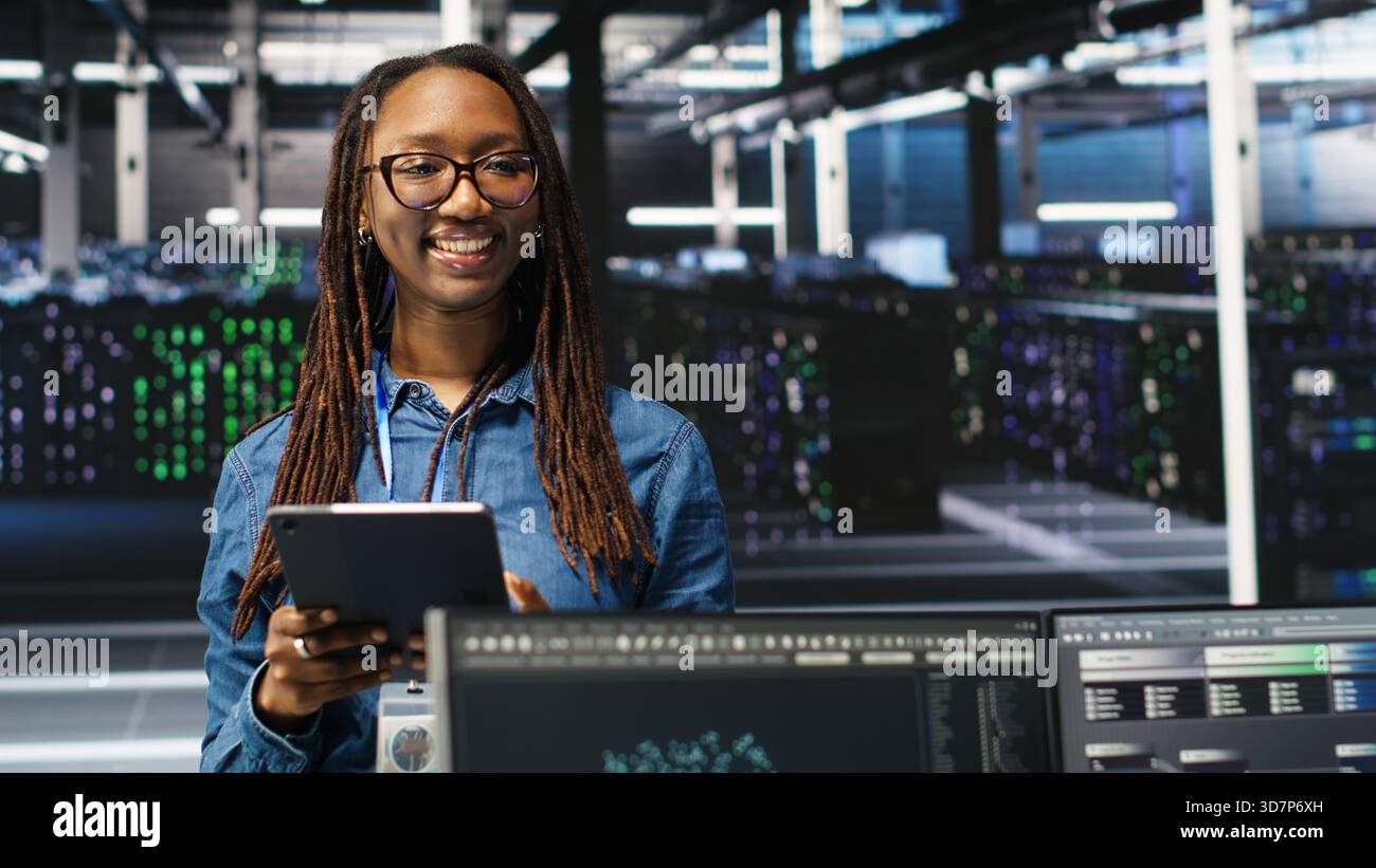 Portrait of upbeat server hub software developer using node tree software to optimize system health. Radiant data center staff member analyzing rigs issues using AI visualization, camera B Stock Photo