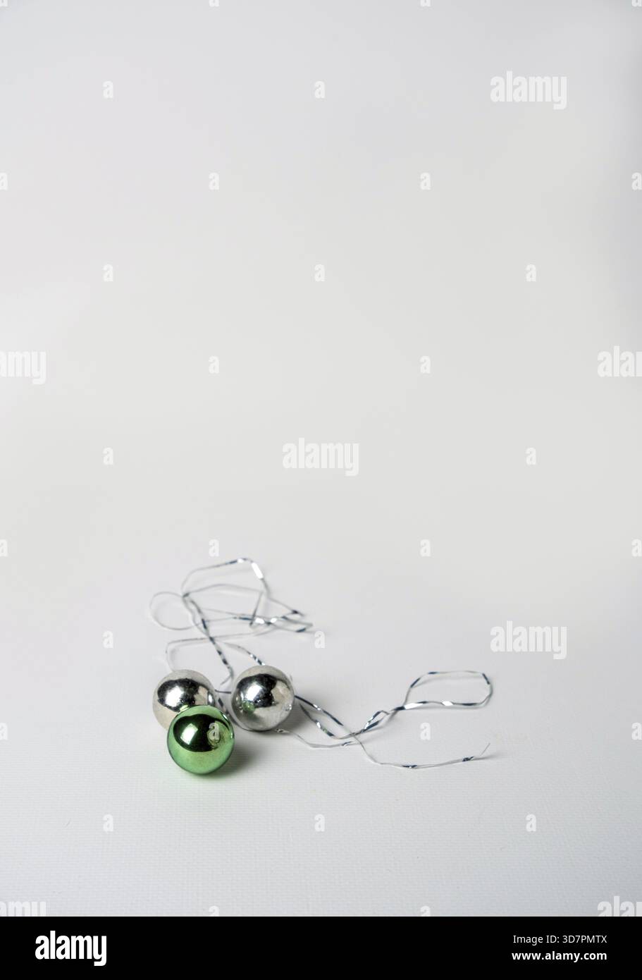Green and silver Christmas tree balls and tinsel on a white background, space for text Stock Photo