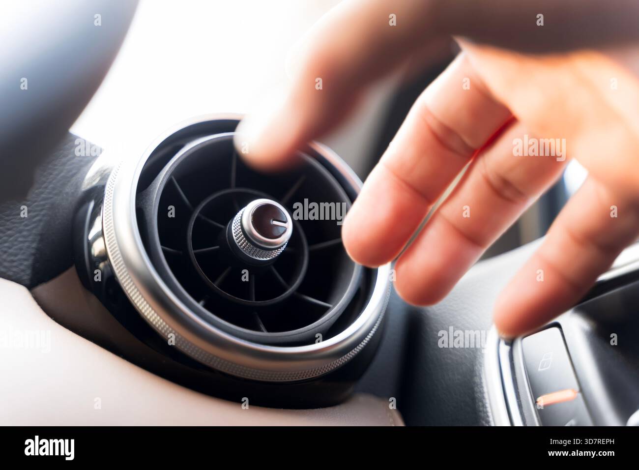 Close-up shot of a hand adjusting the air vent inside a modern car interior, highlighting airflow control, comfort, and temperature adjustment details Stock Photo