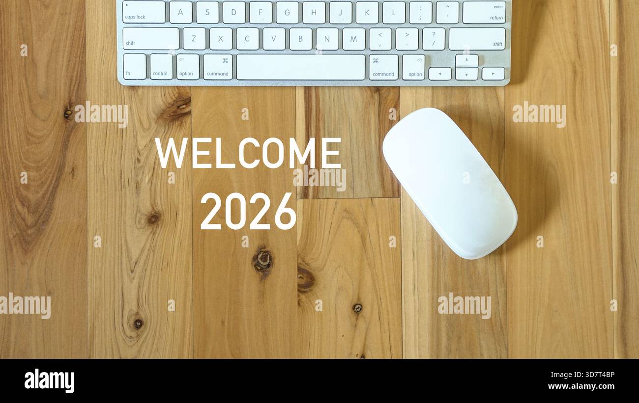 Welcome 2026, next to computer mouse and keyboard. Top view. Stock Photo