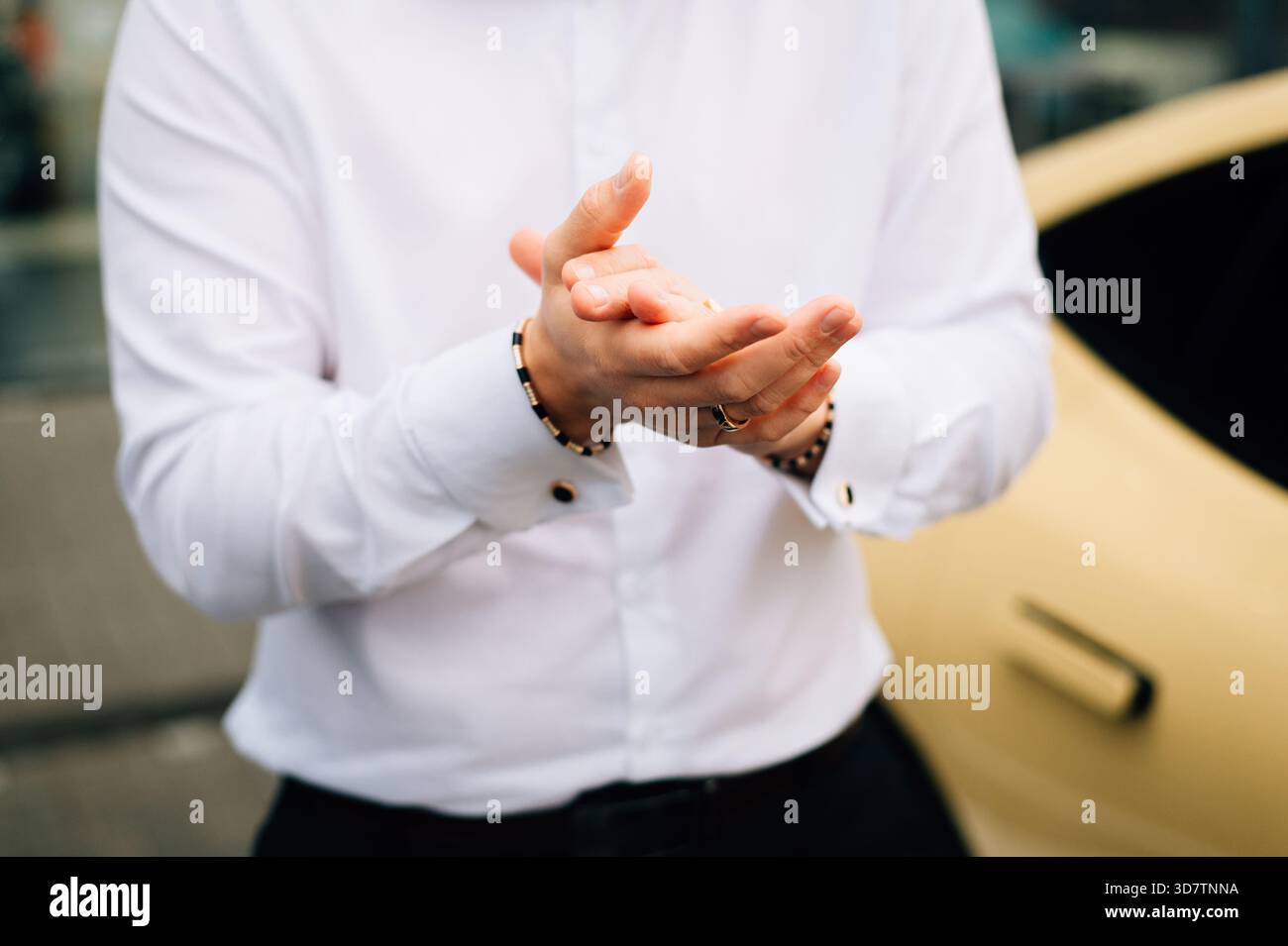 A man in a white shirt rubs his hands. High quality photo Stock Photo