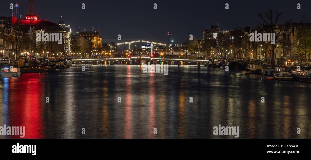 Panoramic night view of the Amstel river in Amsterdam. The long ...