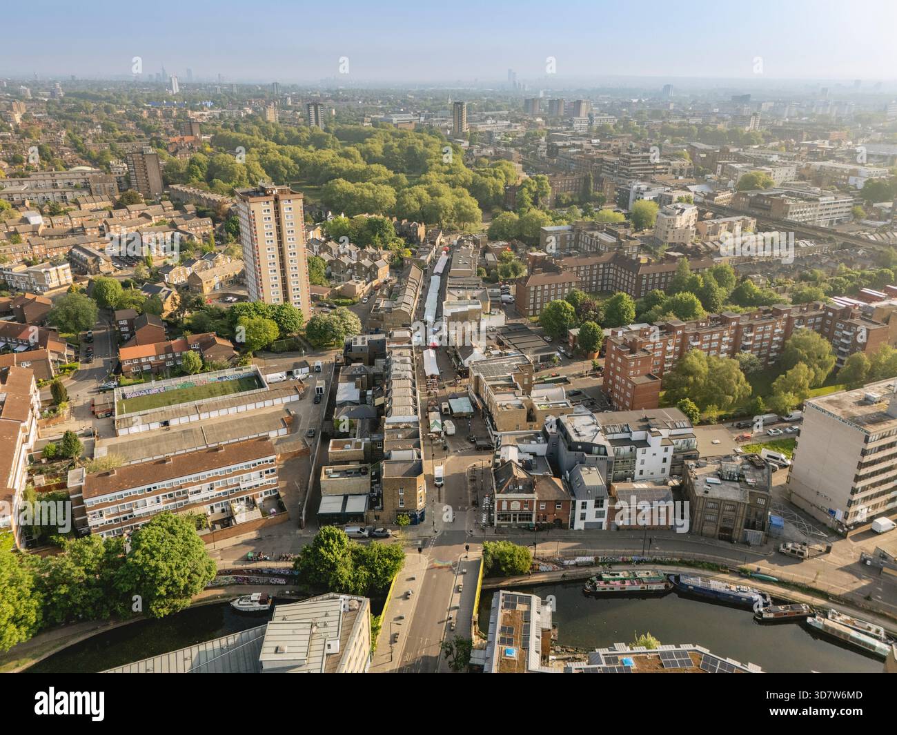 Aerial view of a cityscape with green parks and residential buildings under a clear sky. London, UK Stock Photo