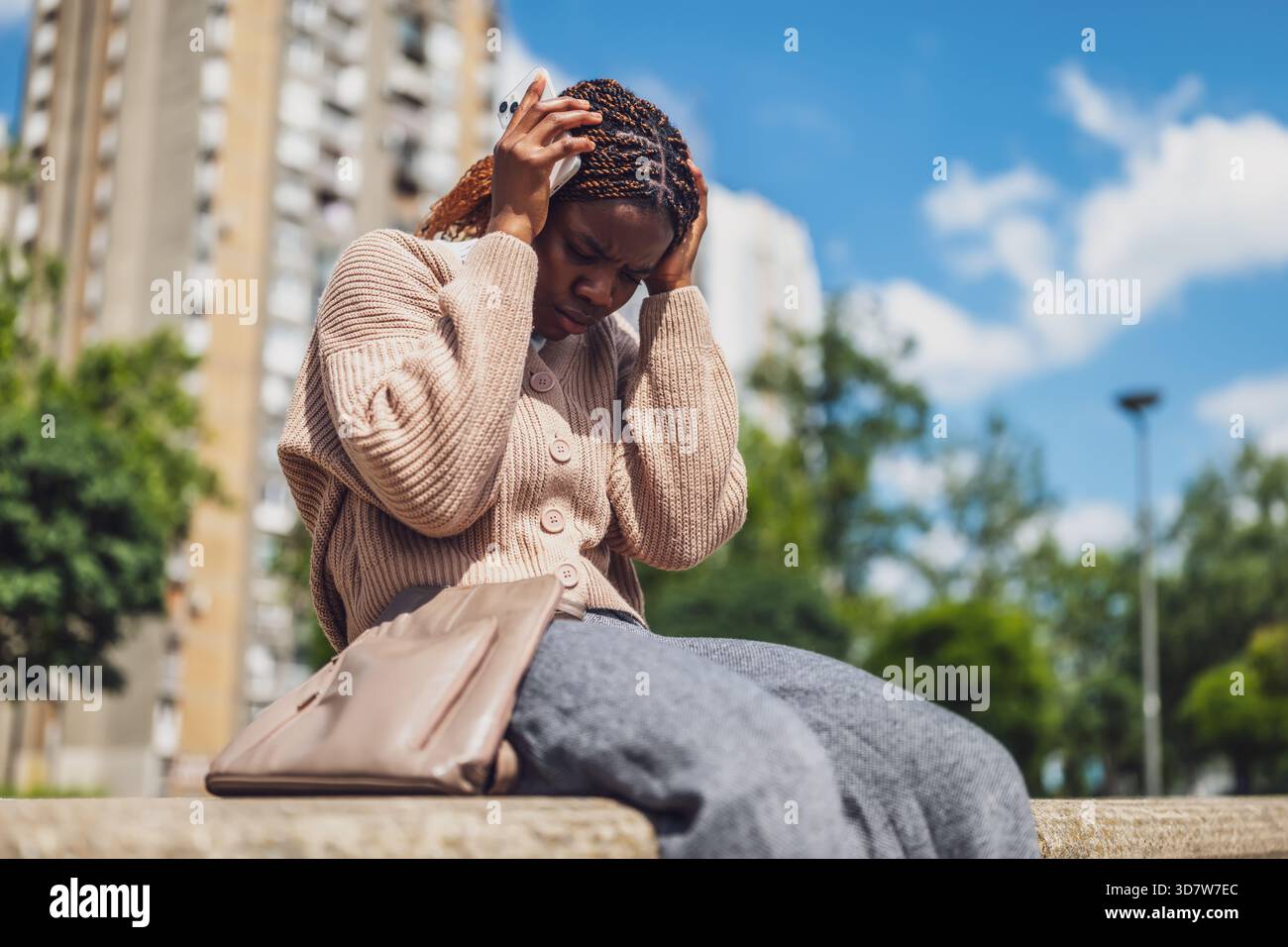 Young black woman is distraught while using her smartphone. Stock Photo