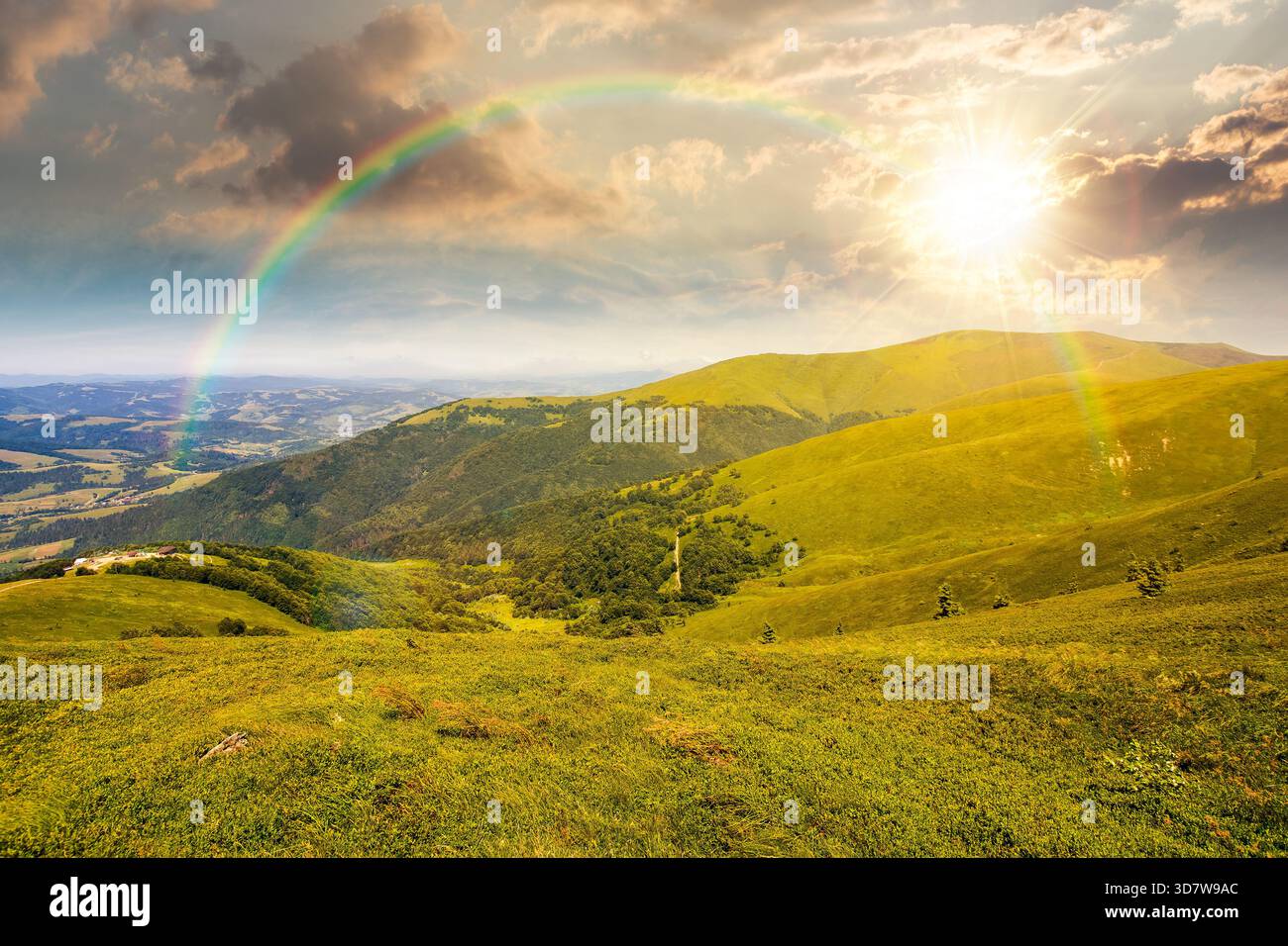 alpine meadows in mountains in summer at sunset. beautiful view of rolling hills with lush green grass under blue sky in evening light. travel destina Stock Photo