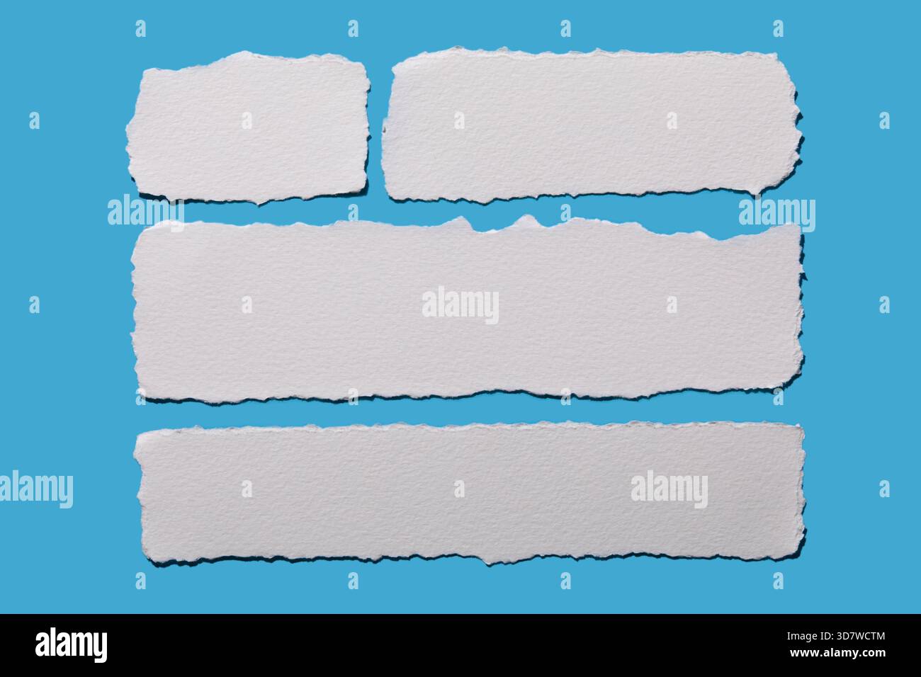 Strips of white torn paper on blue background Stock Photo