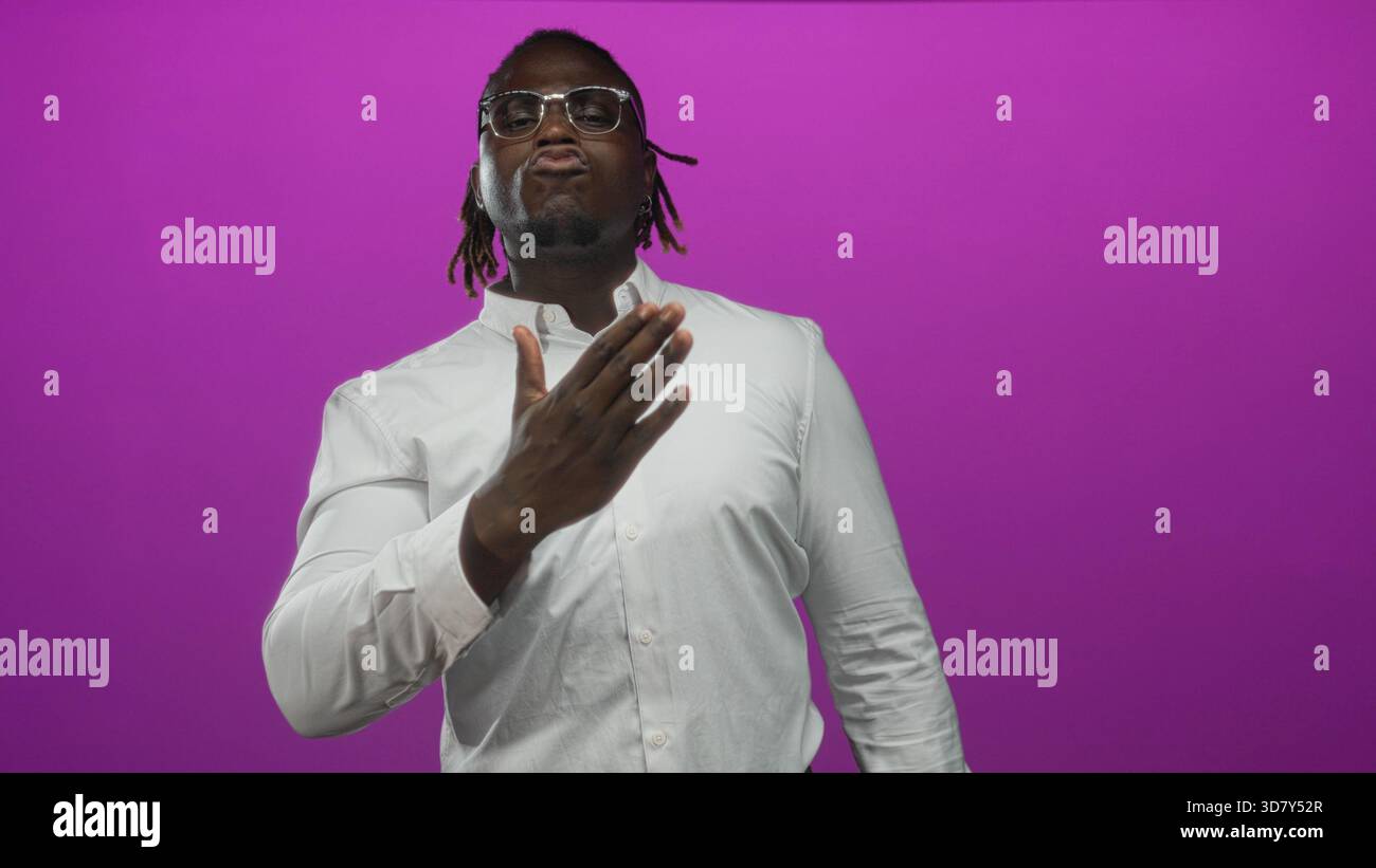 Man pointing thumbs to chest in purple studio wearing white shirt and ...