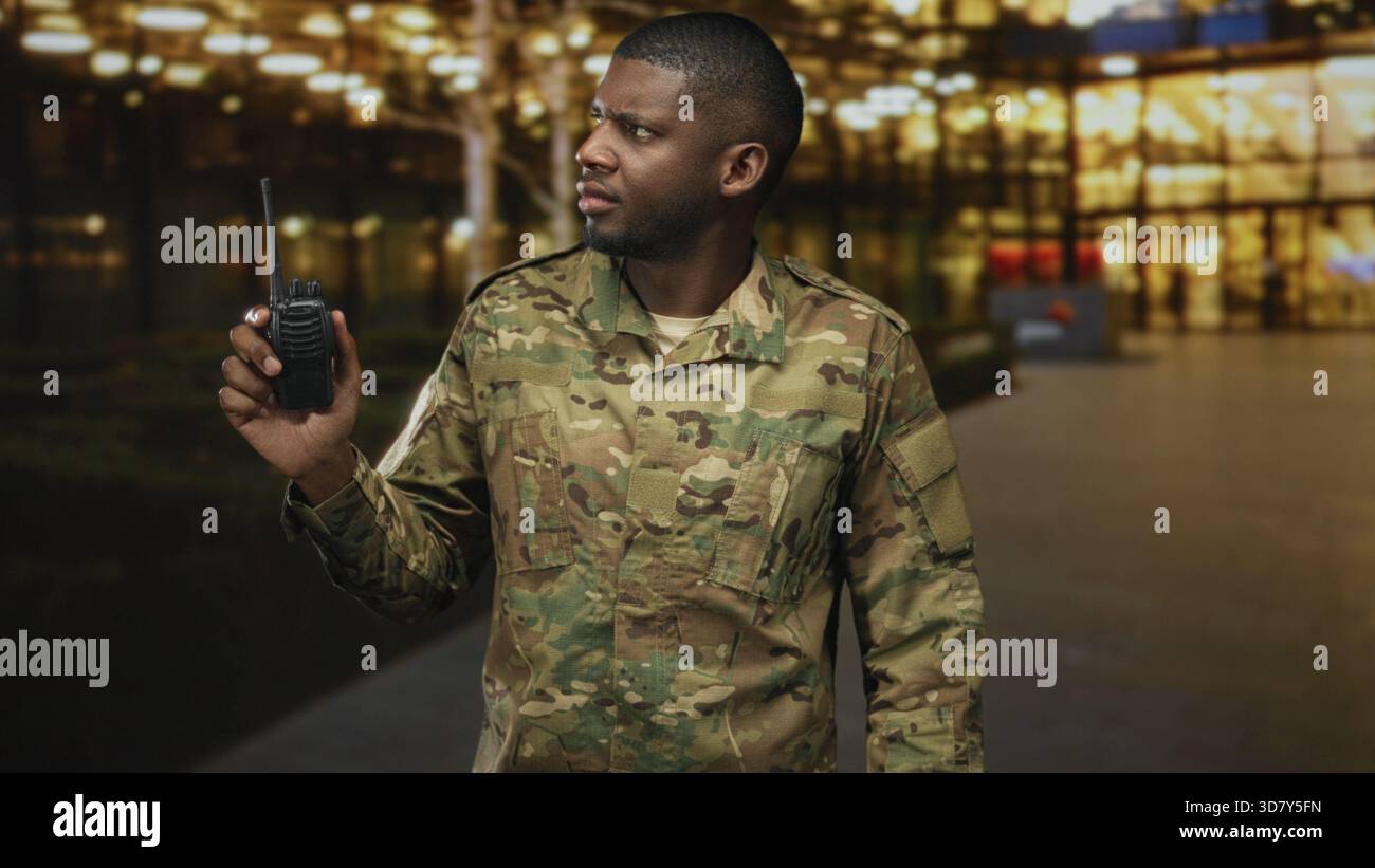 Man soldier in camouflage holding radio to ear while scanning an ...