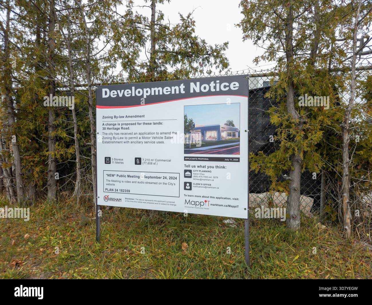 Outdoor development notice sign announcing proposed zoning changes for gas bar and drive-through restaurant. - Smartphone Captured Stock Image