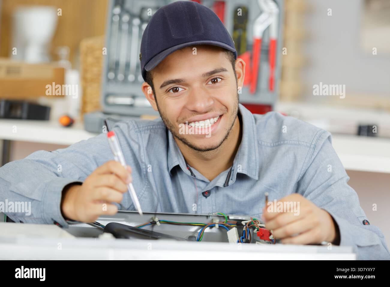 young serviceman repairing washing machine Stock Photo