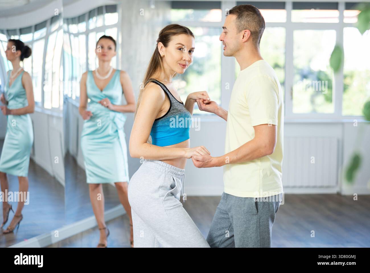 Positive man and woman practicing samba in dance class Stock Photo