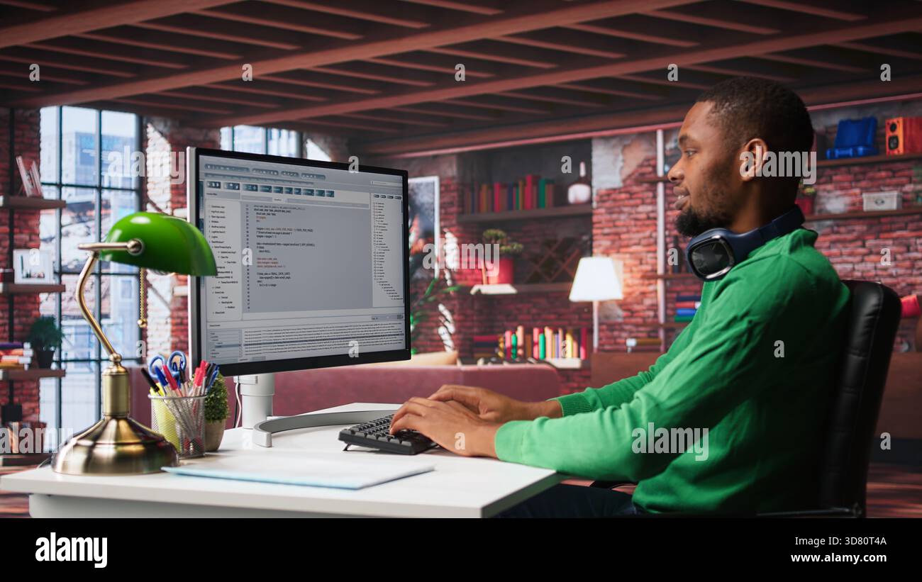 Tech savvy black engineer developing secure online program at home. Surrounded by binary data, freelancer works on interface design, script optimizations and network systems. Camera B. Stock Photo