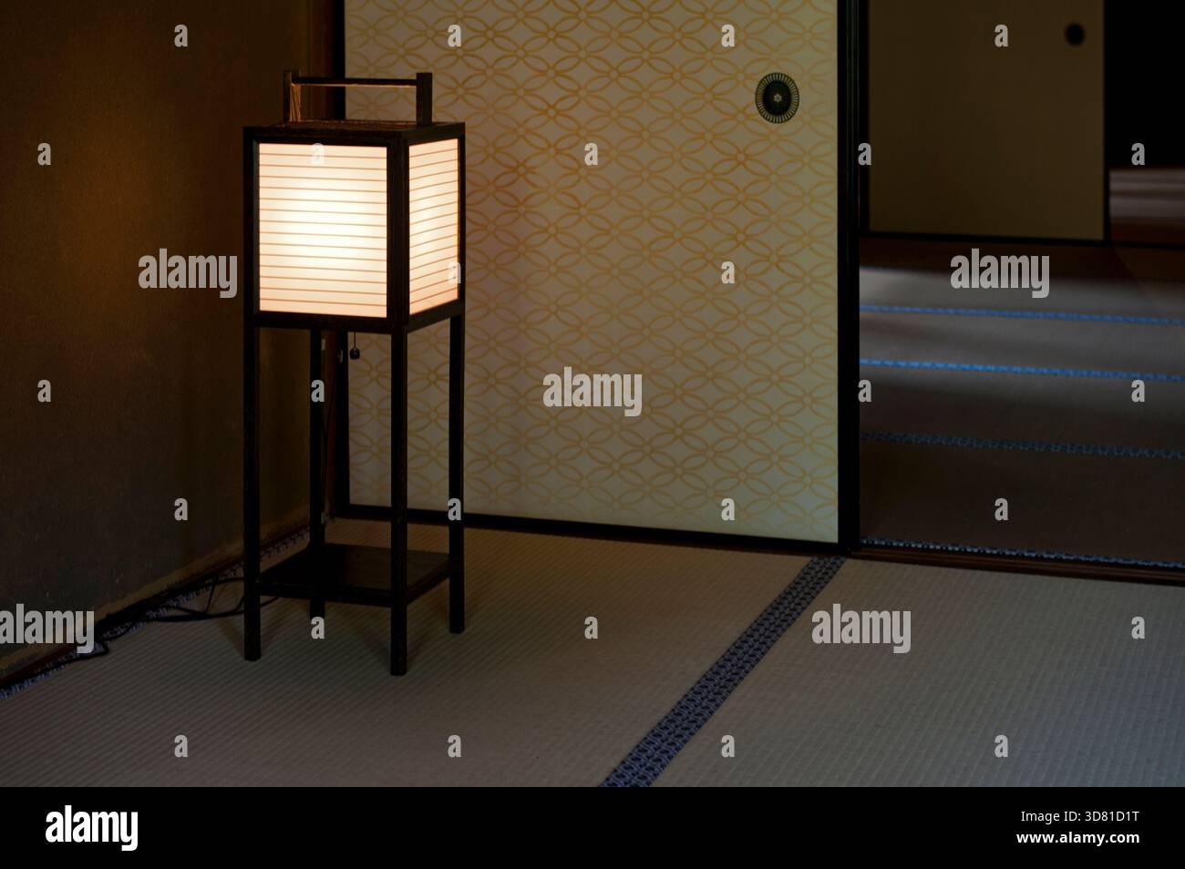Washi paper and wood frame floor lantern casts a gentle glow in a tatami mat room inside the Hikone Castle Museum for a Japanese aesthetic in Japan. Stock Photo