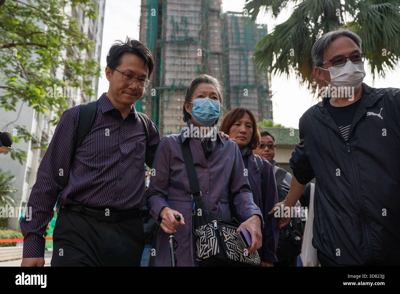 People leaving a community center where they view photos of deceased  victims to identify them as a major fire engulfed several residential  buildings at Wang Fuk Court on November 28, 2025 in