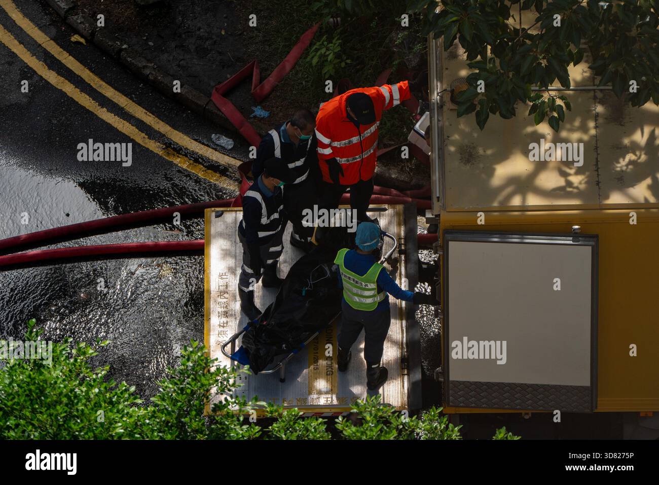 Hong Kong, Hong Kong. 28th Nov, 2025. Workers moving a body in a body bag  onto a truck where a major fire engulfs several residential buildings at  Wang Fuk Court on November