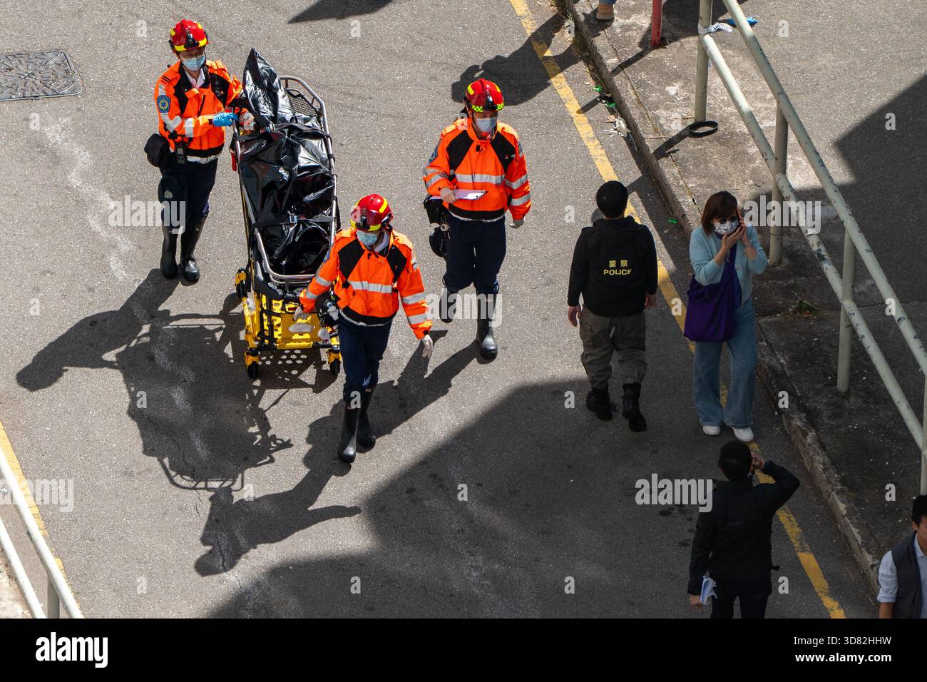 Paramedics pulling a body in a body bag on a stretcher near the scene of  where a major fire engulfs several residential buildings at Wang Fuk Court  on November 28, 2025 in