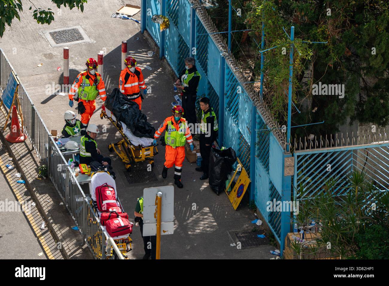 Hong Kong, Hong Kong. 28th Nov, 2025. Paramedics pulling a body in a body  bag on a stretcher near the scene of where a major fire engulfs several  residential buildings at Wang