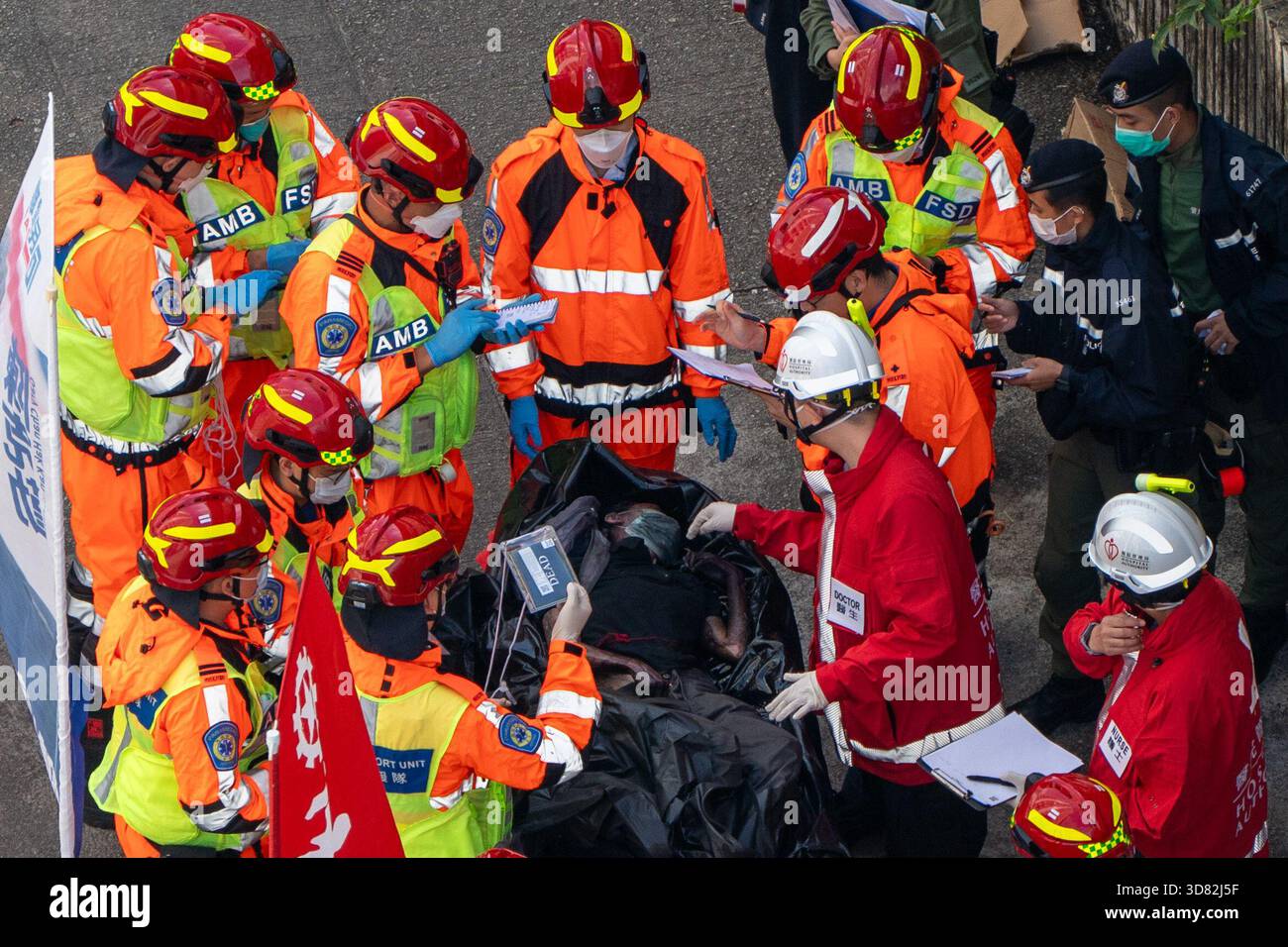 Hong Kong, Hong Kong. 28th Nov, 2025. SENSITIVE MATERIAL, THIS IMAGE MAY  OFFEND OR DISTURB - Paramedics and doctors inspecting a body in a body bag  near the scene of where a