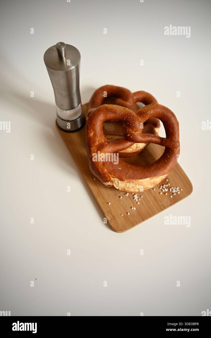 Clean Studio Shot: Two German Pretzels with Salt Shaker on White Background Stock Photo