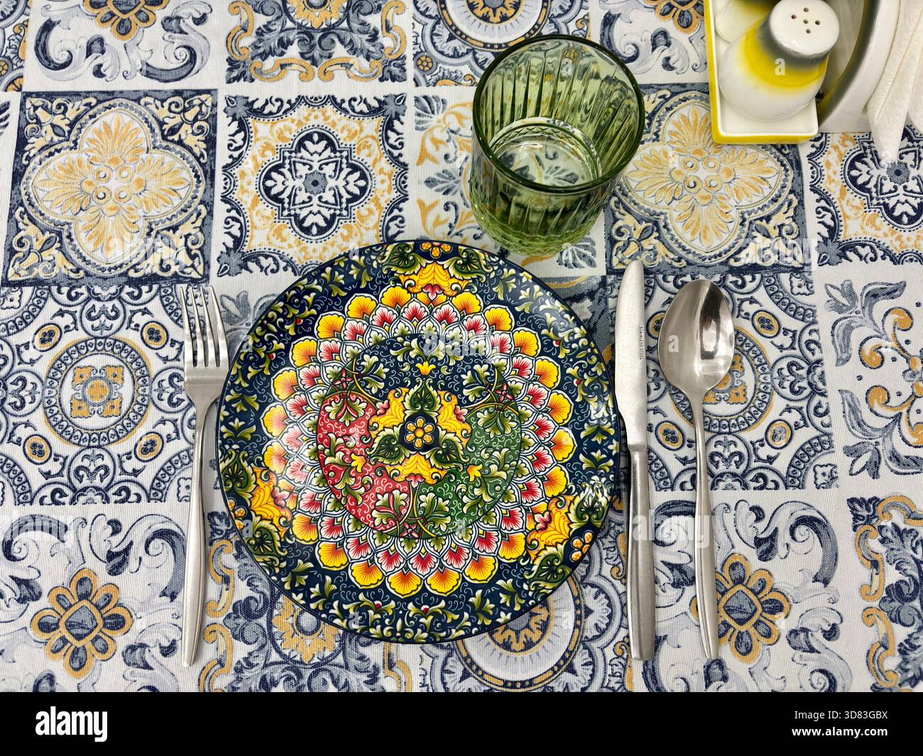 Vibrantly colored plate with mandala pattern set on tablecloth Stock Photo
