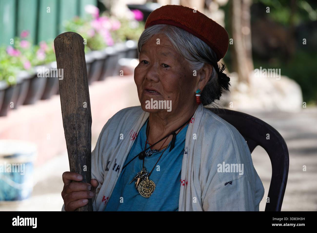 Woman pounding fermented millets in a village in Arunachal Pradesh Stock Photo