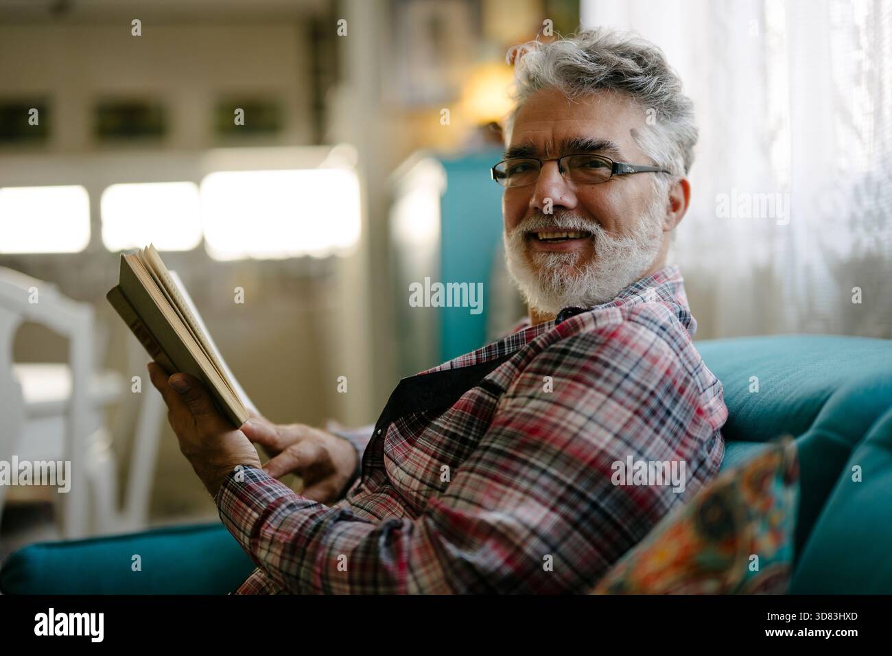 Older man enjoying a book while sitting comfortably Stock Photo