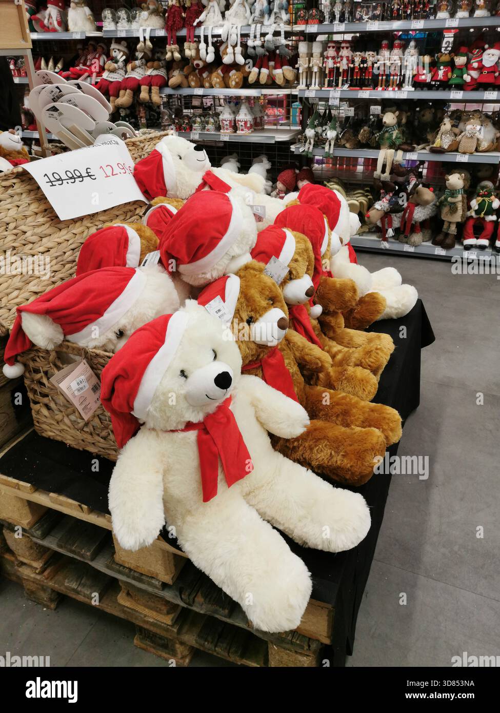 Multiple teddy bears wearing Santa hats and red scarves are arranged for sale. They are displayed in a store. France - Smartphone Captured Stock Image