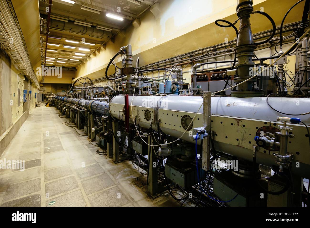 Large metal tube of particle accelerator with connected pipes. Old ...