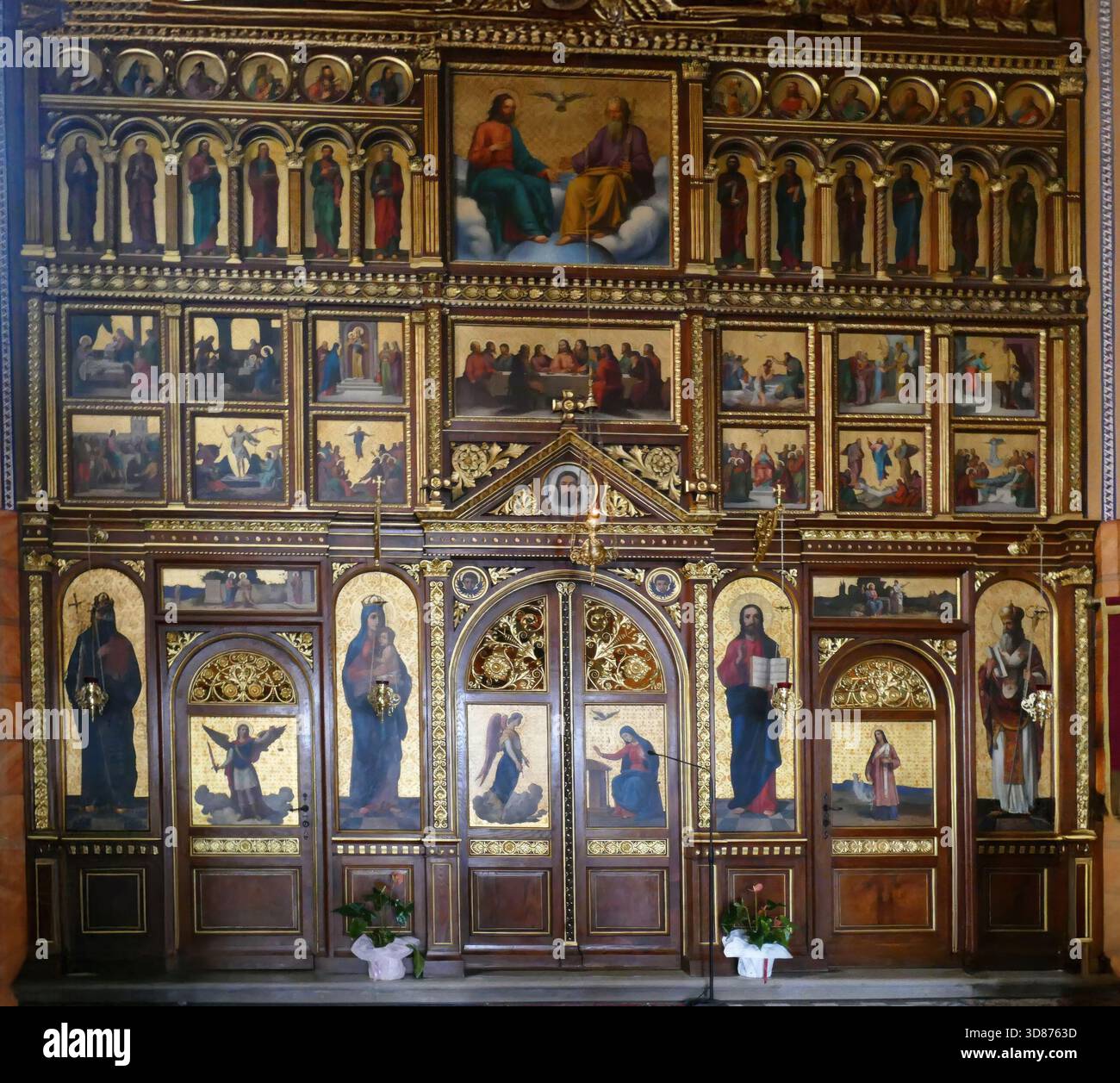 Richly decorated iconostasis with golden frames and numerous religious ...