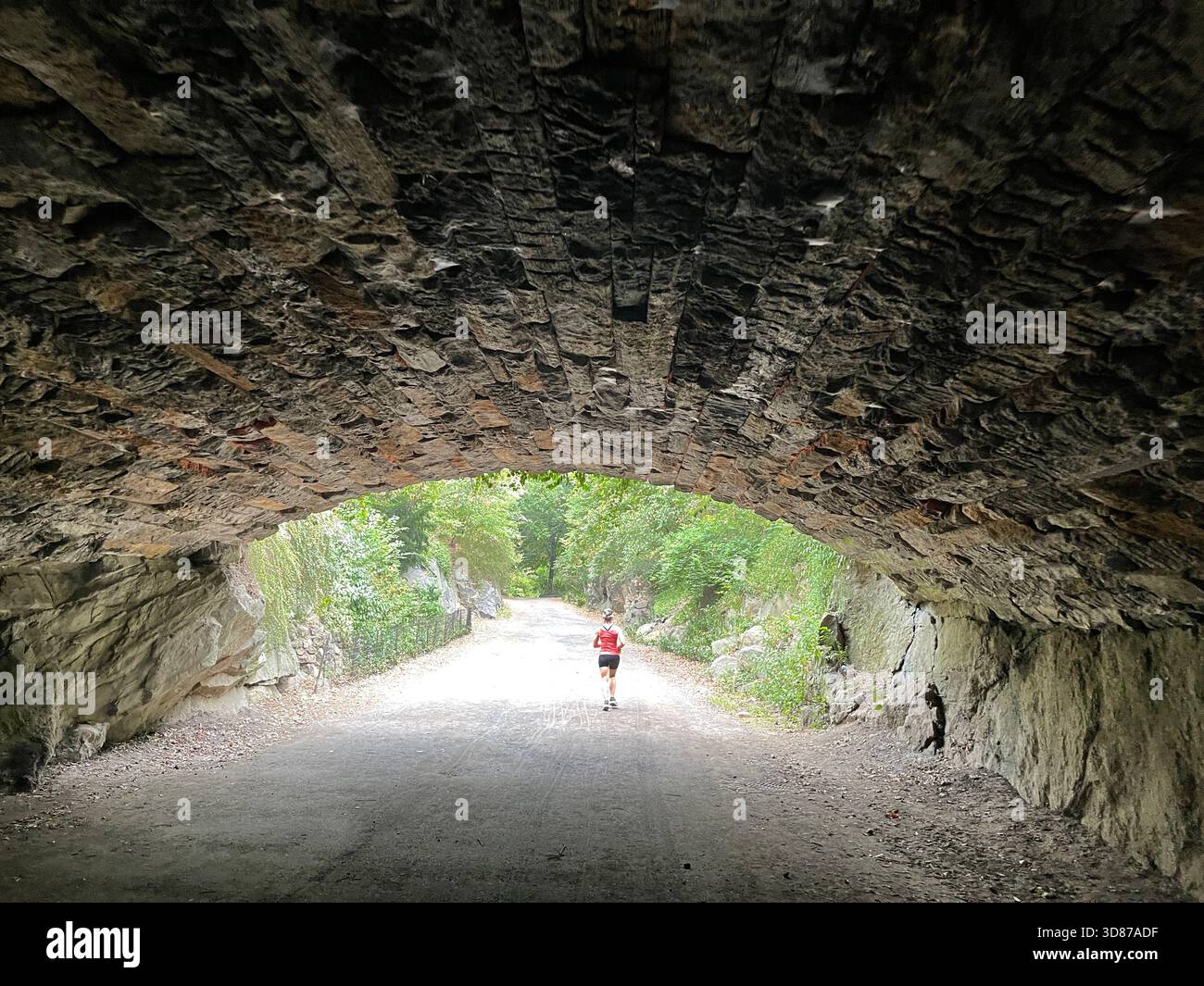 A morning runner passing through the arch in Central Park, NYC. - Smartphone Captured Stock Image