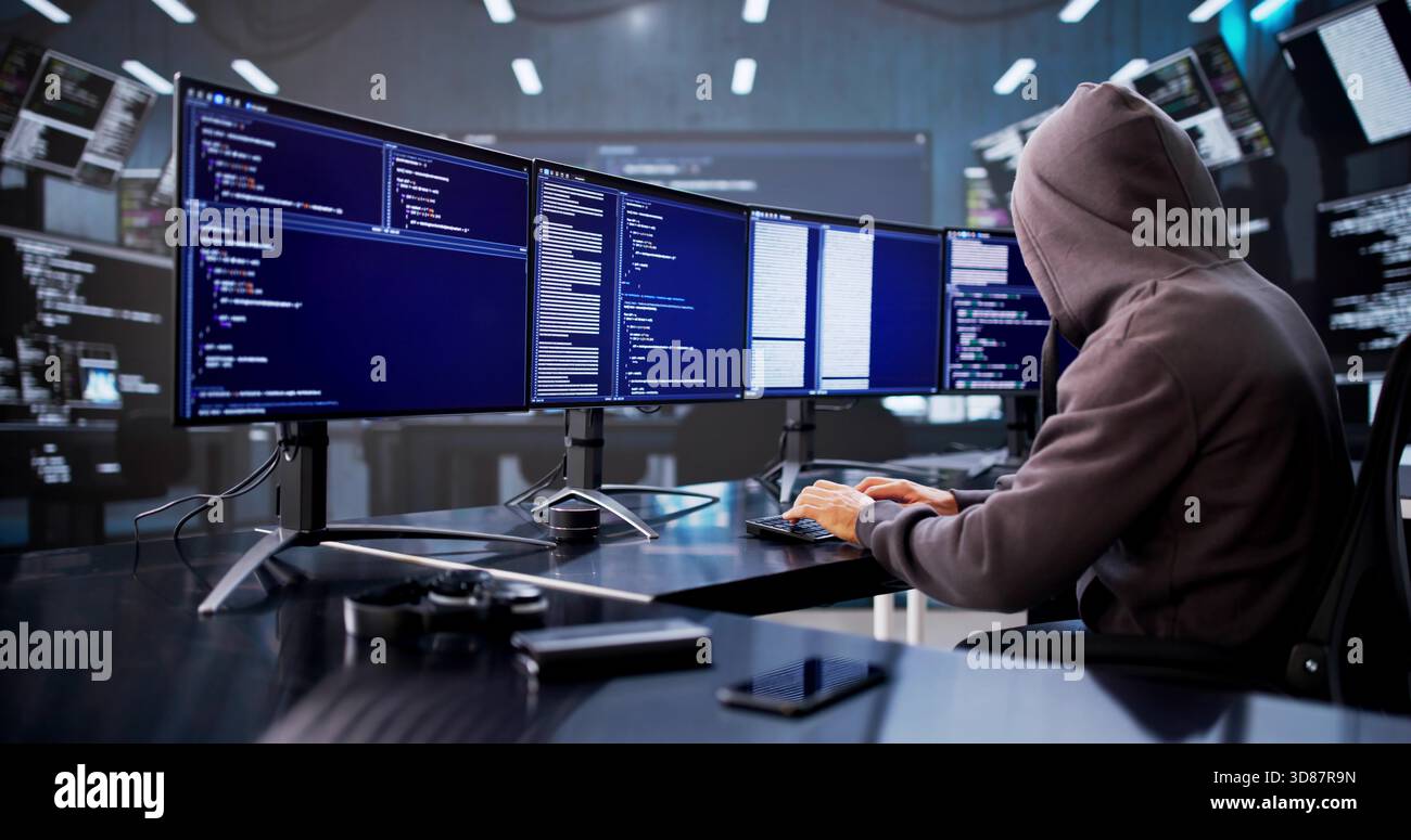 Mid-aged Caucasian Man In Hoodie Stealing Data Online Using Computers. Stock Photo