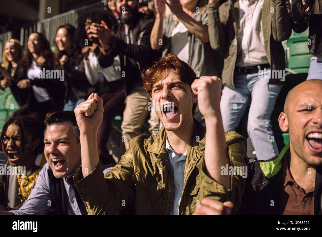 Ecstatic young man shouting and cheering while watching game in stadium ...