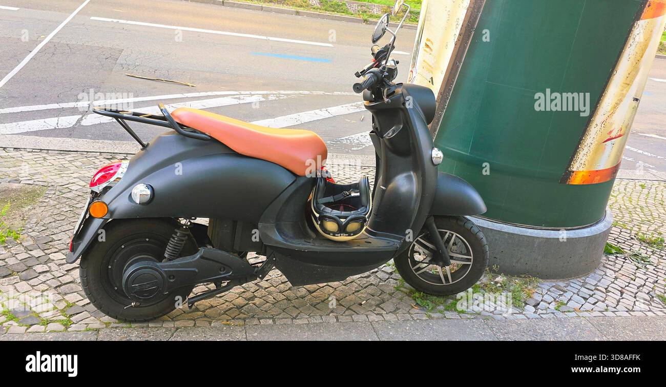 Berlin, Germany - September 19, 2025: Stylish black scooter is parked near urban street with modern architecture nearby. - Smartphone Captured Stock Image