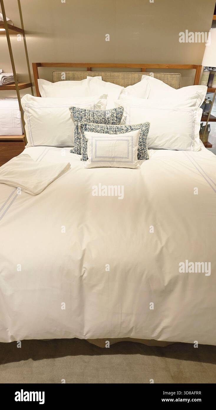 Berlin, Germany - September 19, 2025: Luxurious white bedding set features decorative pillows on a stylish bed with soft textures. - Smartphone Captured Stock Image