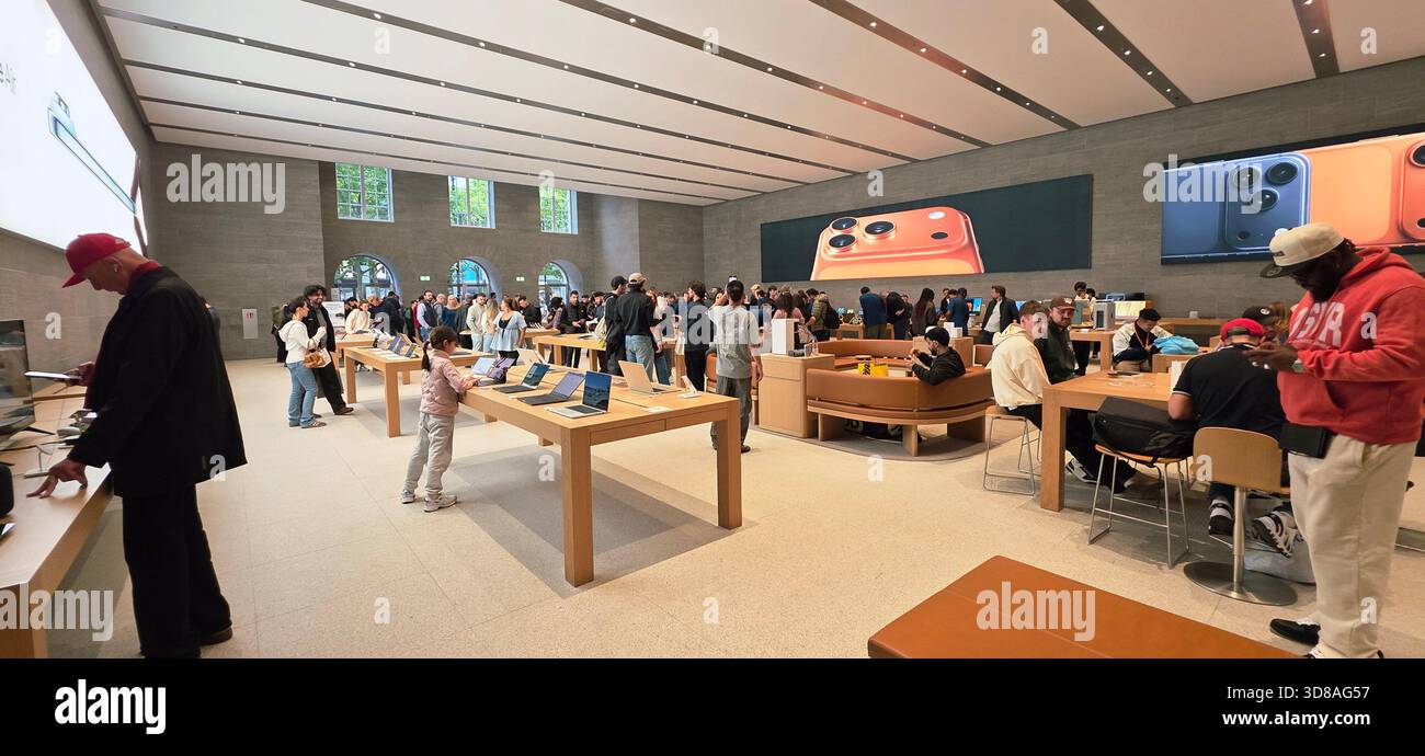 Berlin, Germany - September 22, 2025: Busy Apple Store features customers engaging with latest devices and technology. - Smartphone Captured Stock Image