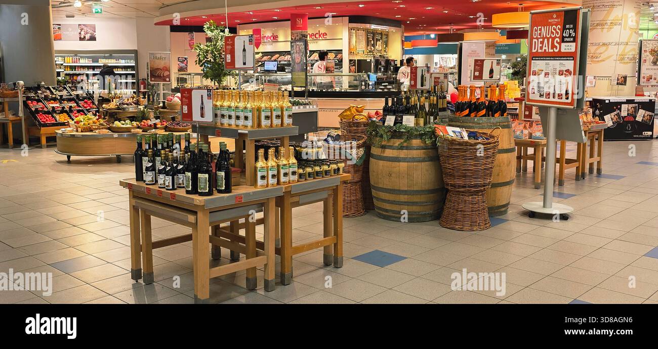 Berlin, Germany - September 19, 2025: Wine bottles arranged on tables with wooden barrels and fresh produce nearby. - Smartphone Captured Stock Image