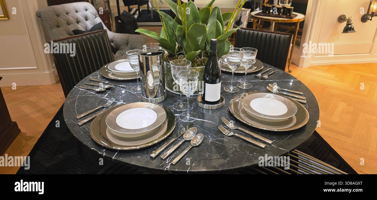 Berlin, Germany - September 19, 2025: Elegant dining table features glassware, silverware, and a decorative plant centerpiece. - Smartphone Captured Stock Image