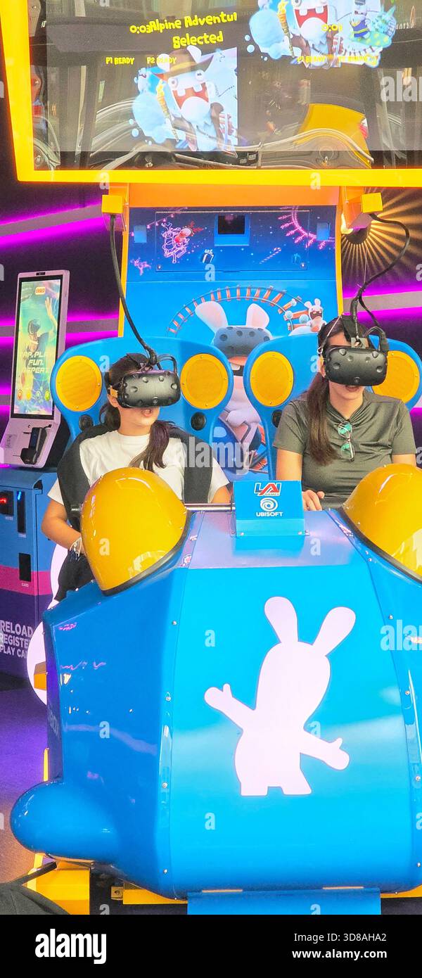 Berlin, Germany - September 22, 2025: Two women are immersed in a virtual reality ride at a vibrant gaming arcade. - Smartphone Captured Stock Image
