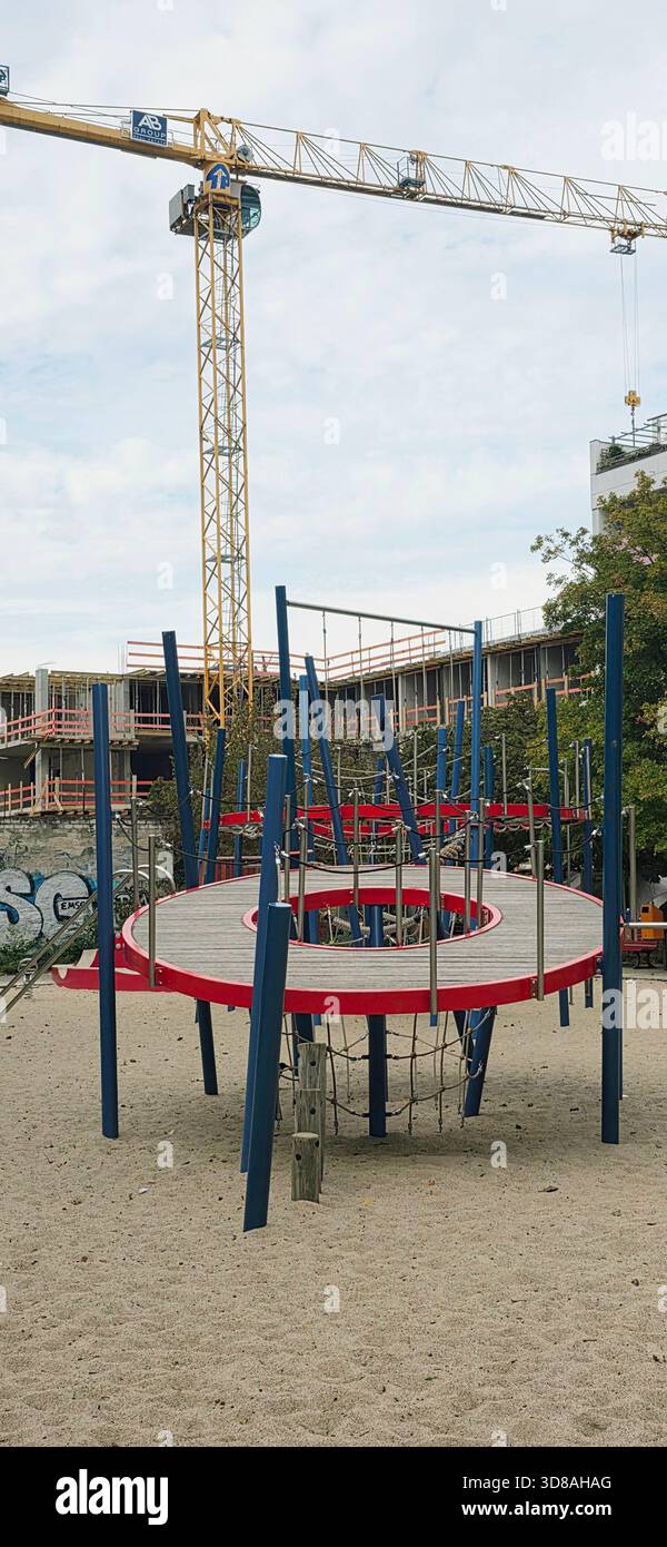 Berlin, Germany - September 25, 2025: Modern playground features climbing frame with construction site in the background. - Smartphone Captured Stock Image