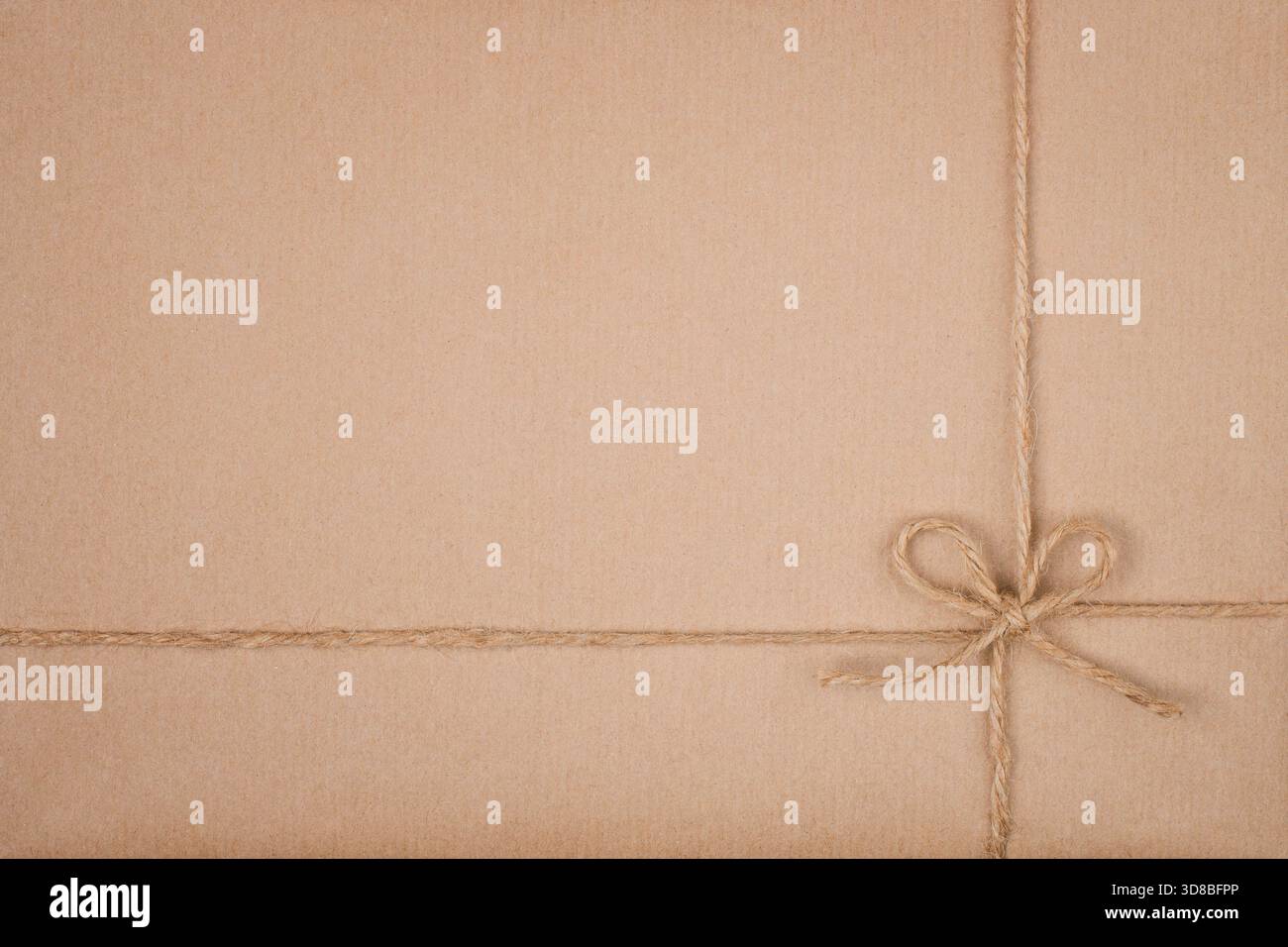 Twine String Tied in Bow on Kraft Eco Friendly Paper Texture Stock Photo