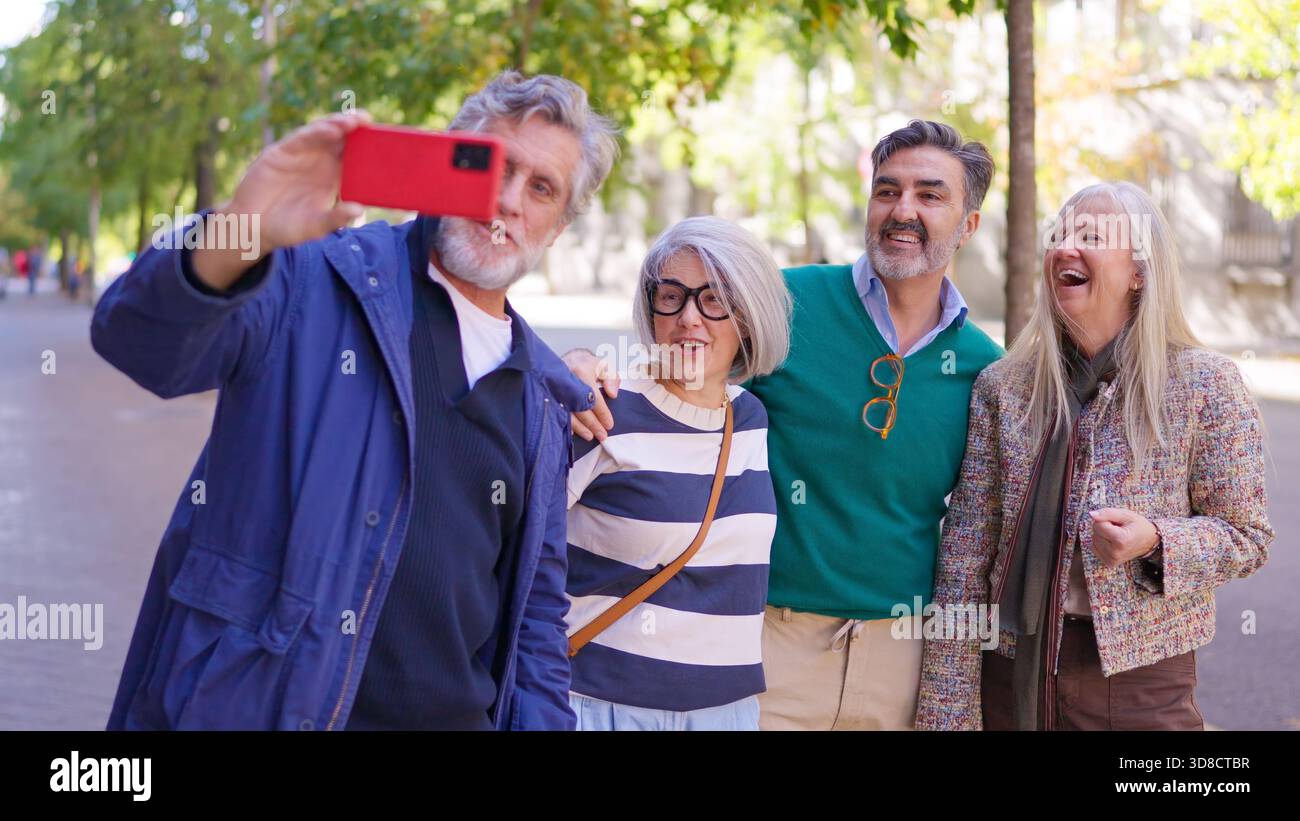 Happy senior friends taking a group selfie outdoors Stock Photo