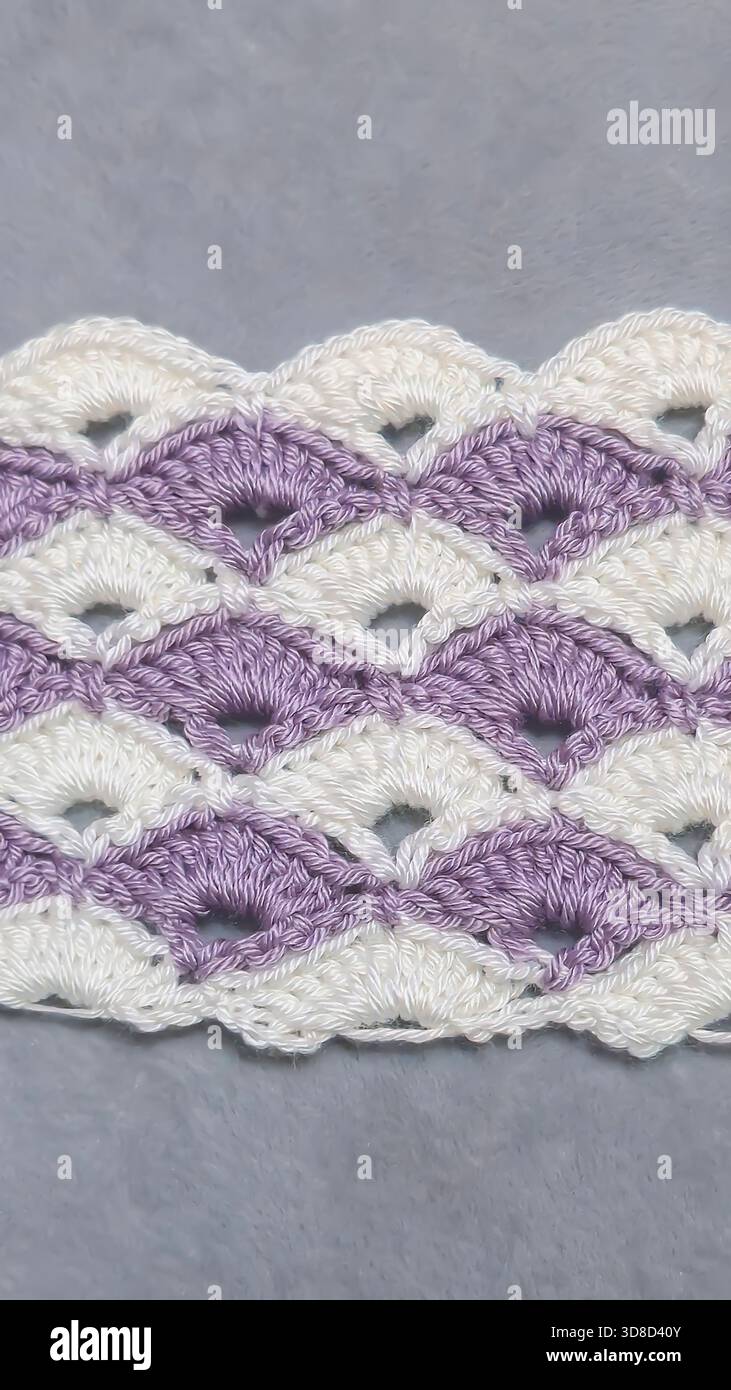 Knitting patterns for sweaters, hats, and other items using light-colored yarn on a light background. Copy space. Stock Photo