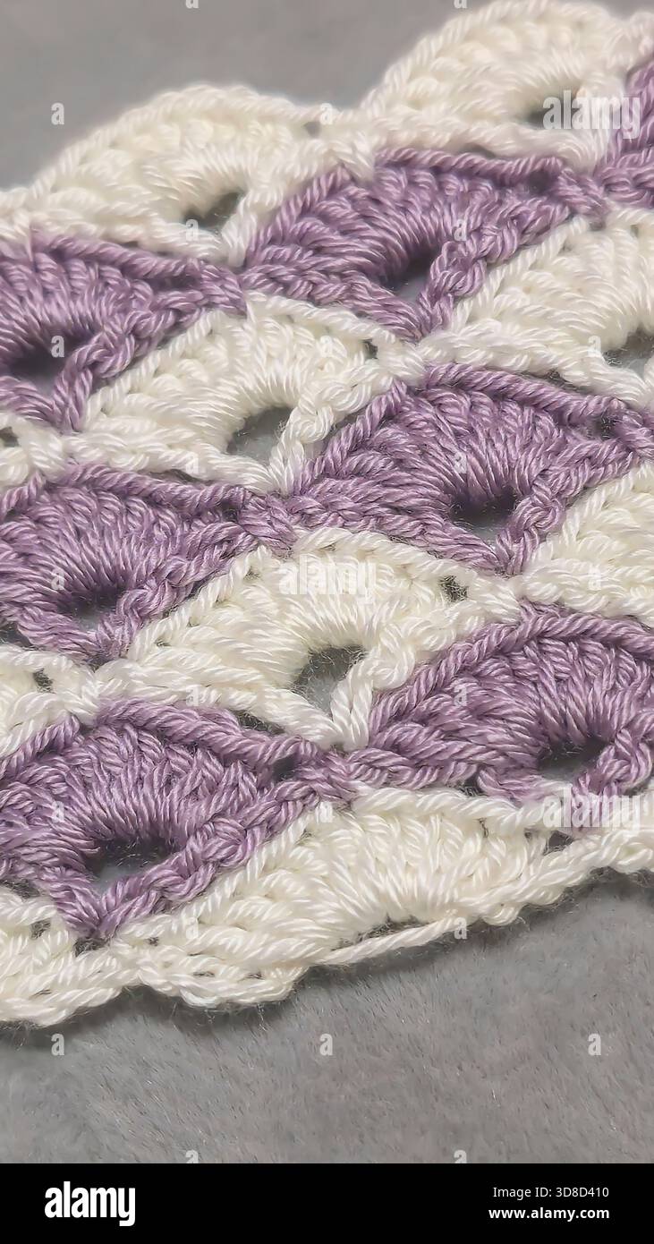 Knitting patterns for sweaters, hats, and other items using light-colored yarn on a light background. Copy space. Stock Photo