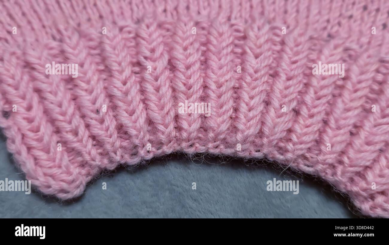 Knitting patterns for sweaters, hats, and other items using light-colored yarn on a light background. Copy space. Stock Photo