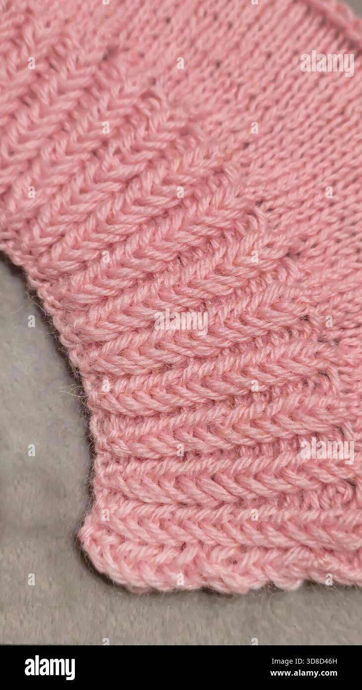 Knitting patterns for sweaters, hats, and other items using light-colored yarn on a light background. Copy space. Stock Photo